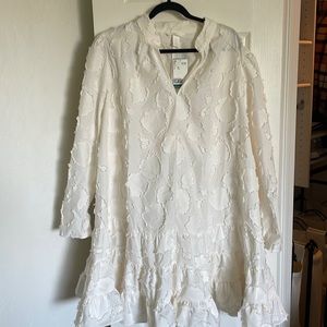 White cocktail length dress with ruffle at hem